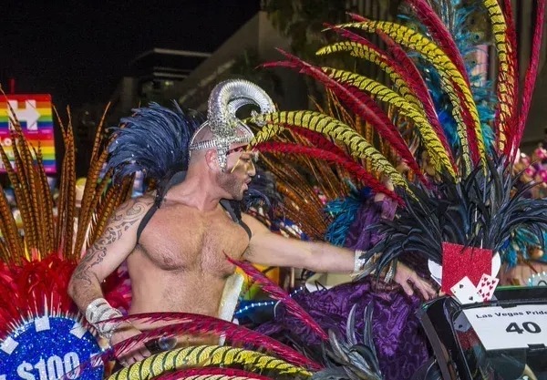 Man in feathered costume at Vegas Halloween parade.